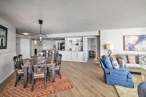 Ein modernes Wohnzimmer mit Essbereich, Küche und einer gemütlichen Sitzecke mit Sofa und Sessel.
