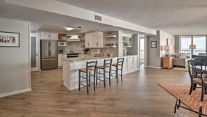 A spacious kitchen with a central island, modern appliances, and a dining area with a table and chairs. - Cambridge 404 - 3 Bedrooms - 2 Are Oceanfront - Amazing! (Pawleys Island)