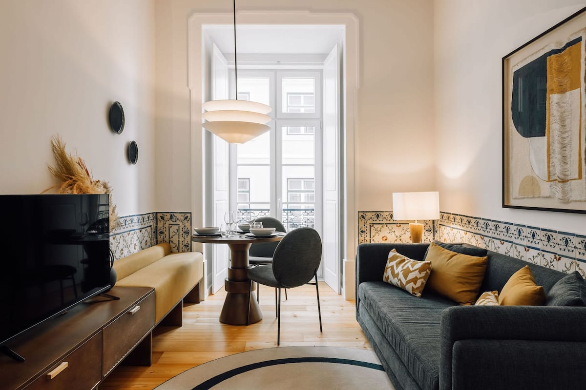 Ein modernes Wohnzimmer mit einer Couch, einem Esstisch und einem Fernseher.
