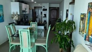 A modern living room with a dining area, a kitchen in the background, and a large plant. - CARTAGENA APARTMENT WITH SEA VIEWS (Cartagena de Indias)