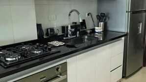 A modern kitchen with a gas stove, stainless steel appliances, and white cabinetry. - CARTAGENA APARTMENT WITH SEA VIEWS (Cartagena de Indias)