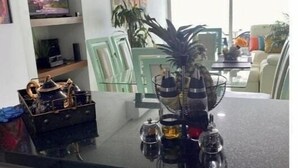 A kitchen with a black countertop, a coffee machine, and a glass cabinet. - CARTAGENA APARTMENT WITH SEA VIEWS (Cartagena de Indias)
