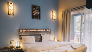 A well-lit bedroom with a large bed, bedside lamps, and a view of the outdoors through a window with curtains. - Luxury villa Diva Goa (Calangute)