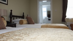 A hotel room with two beds, a wooden headboard, a bedside table with a lamp, and a view of the hallway. - Enjoy the breathtaking view which you Relax at the Aran View Lodge (Doolin)