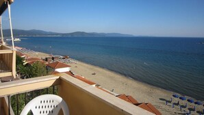 Un balcon avec vue sur une plage et la mer.