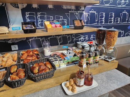 A breakfast buffet with croissants, pastries, and various spreads.