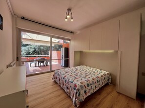 Une chambre avec un lit, un bureau et une vue sur l’extérieur.