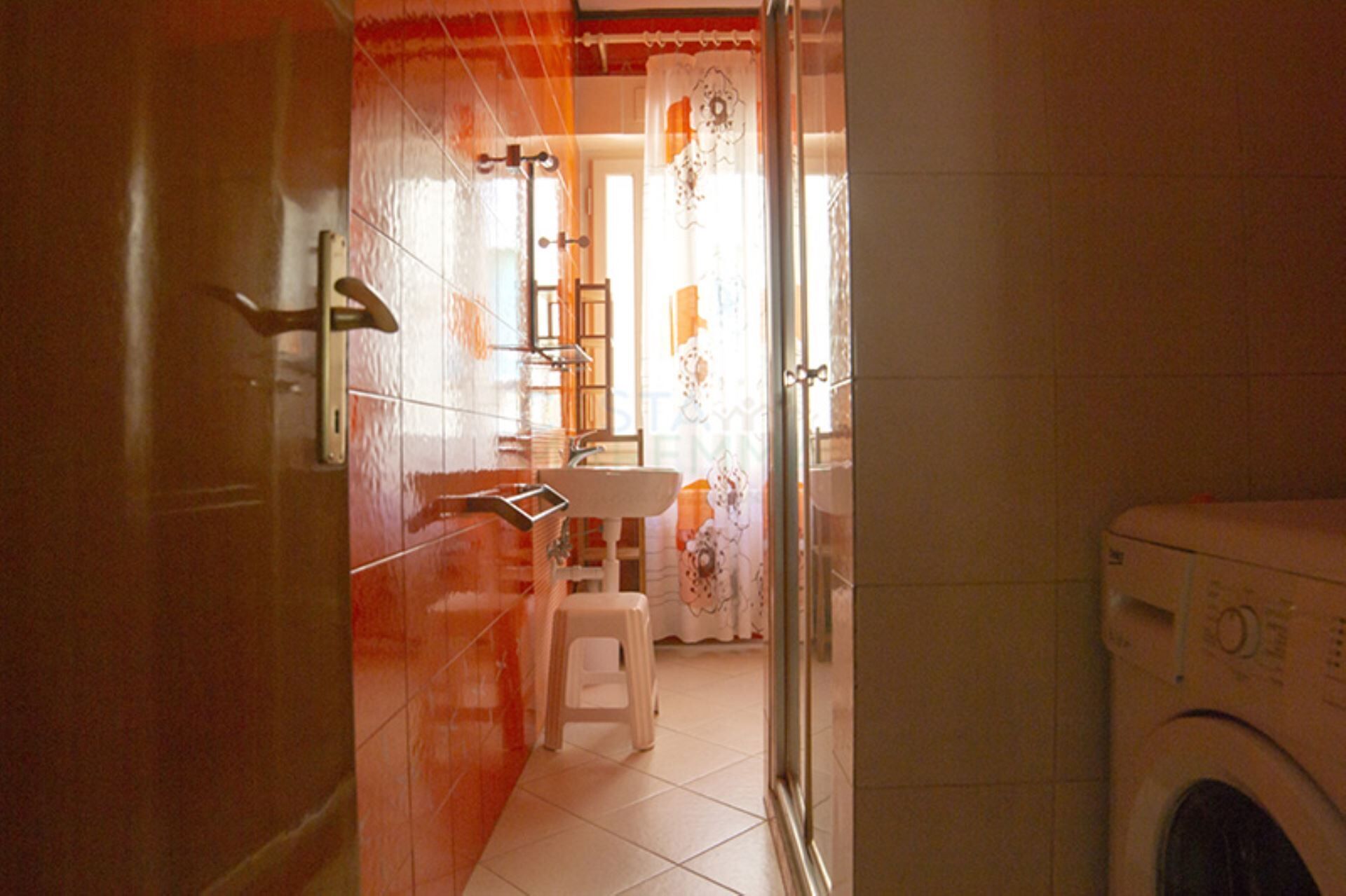 Un bagno con lavatrice, lavandino e toilette.