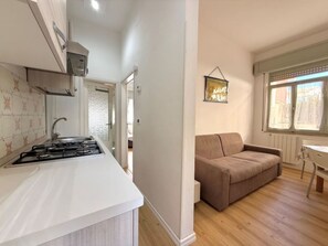 Una cucina moderna con piano cottura a gas, un ripiano bianco e uno schienale in piastrelle.