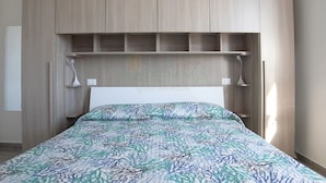 Un dormitorio con cama, cabecero de madera y lámparas de noche.