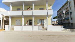 Un edifici de diverses plantes amb un terrat pla, un balcó al segon pis i una escala que condueix a l'entrada.