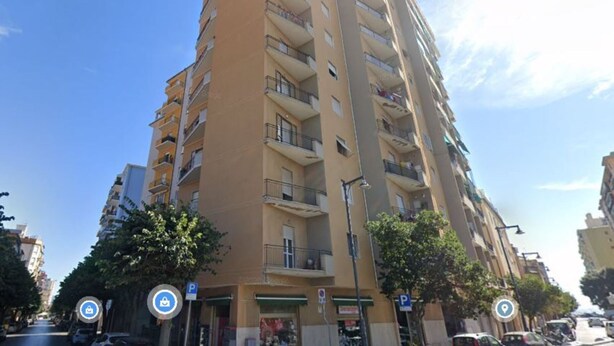 A tall, multi-story building with balconies and a clear sky. - Salvia apartment in Follonica (Follonica)