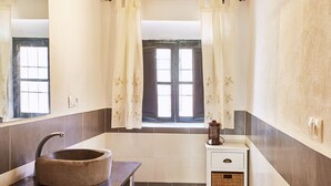 A bathroom with a round sink, a toilet, a window with curtains, and a wall-mounted light fixture. - Rural escape with mountain views (Níjar)