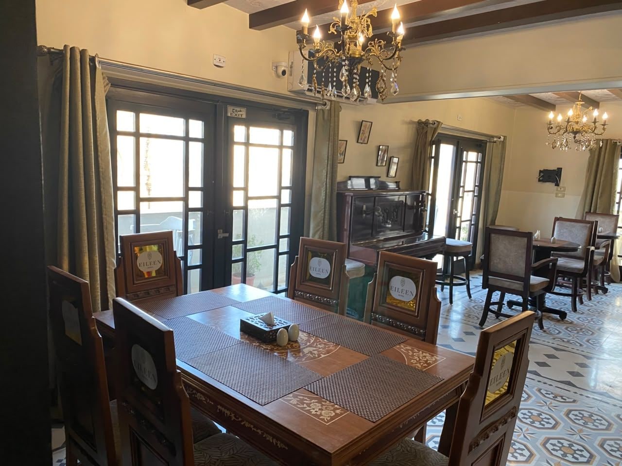 A dining area with a wooden table, chairs, and a chandelier.