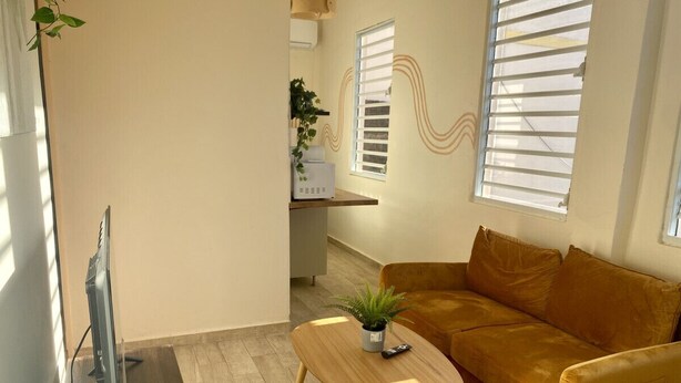 Una sala moderna con un sofá, una mesa de centro y un televisor.