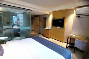 Relax in a spacious room with a large bed, wardrobe, TV, and separate bathroom.