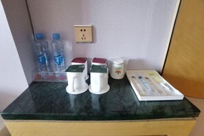Kitchenette with electric kettles, a mug, and writing essentials.