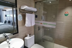 Un baño moderno con cabina de ducha de vidrio, inodoro y lavamanos.