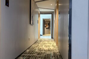 A hallway with patterned flooring and a door leading to a room. - Greentree Alliance Hotel (Ningdu)