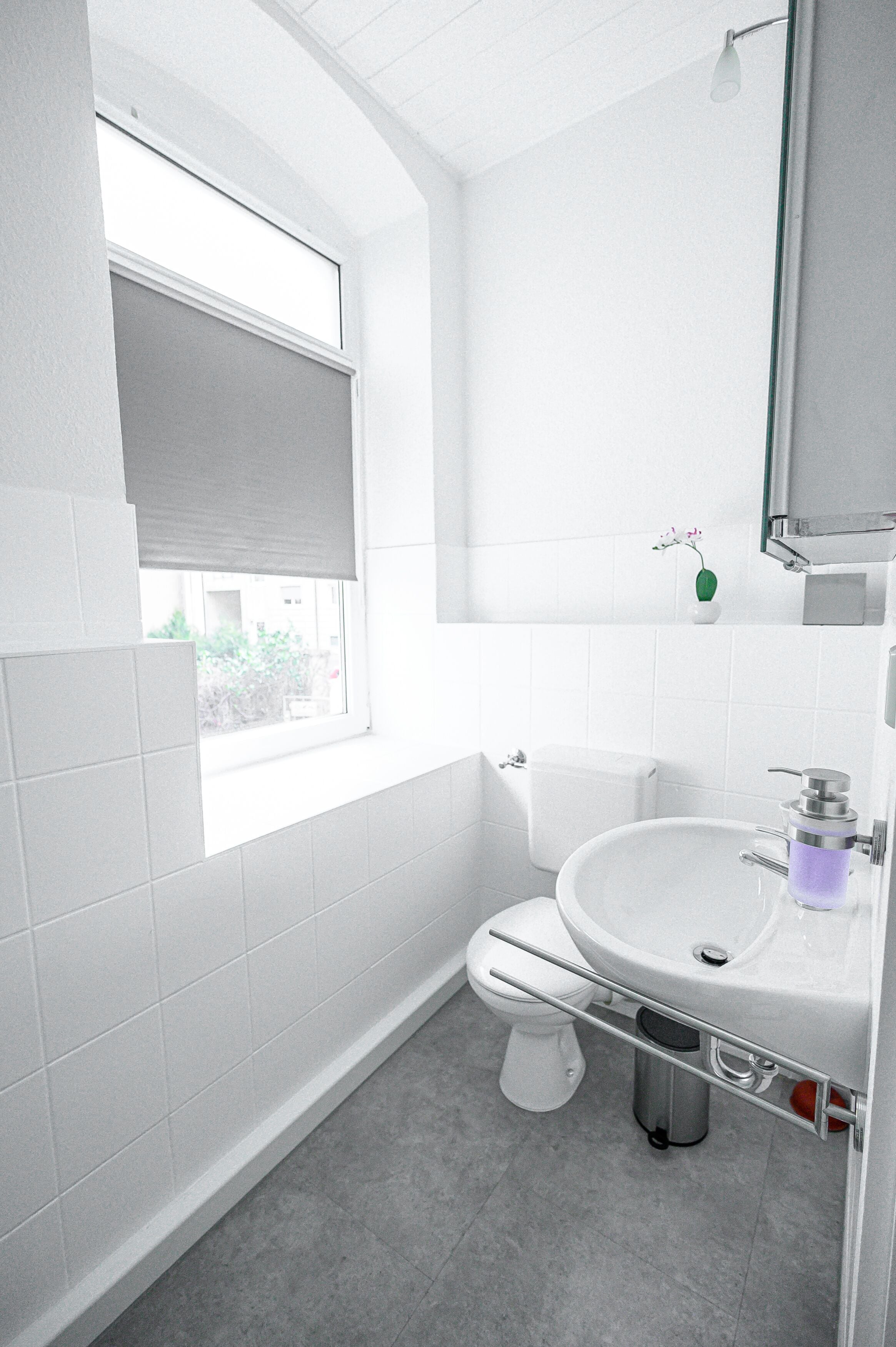 Ein modernes Badezimmer mit Toilette, Waschbecken und Fenster.