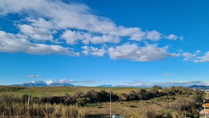 A wide landscape with a clear sky, distant mountains, and a flat field. - Studio Calme et Cosy Bien Équipé (Perpignan)