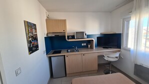 A compact kitchen with a sink, microwave, and a small refrigerator. - Studio Calme et Cosy Bien Équipé (Perpignan)