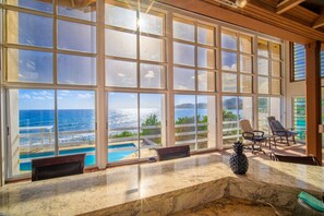 A spacious room with large windows overlooking a pool and ocean. - Sapala 1 - Oceanfront Main House with Shared Pool (Christiansted)
