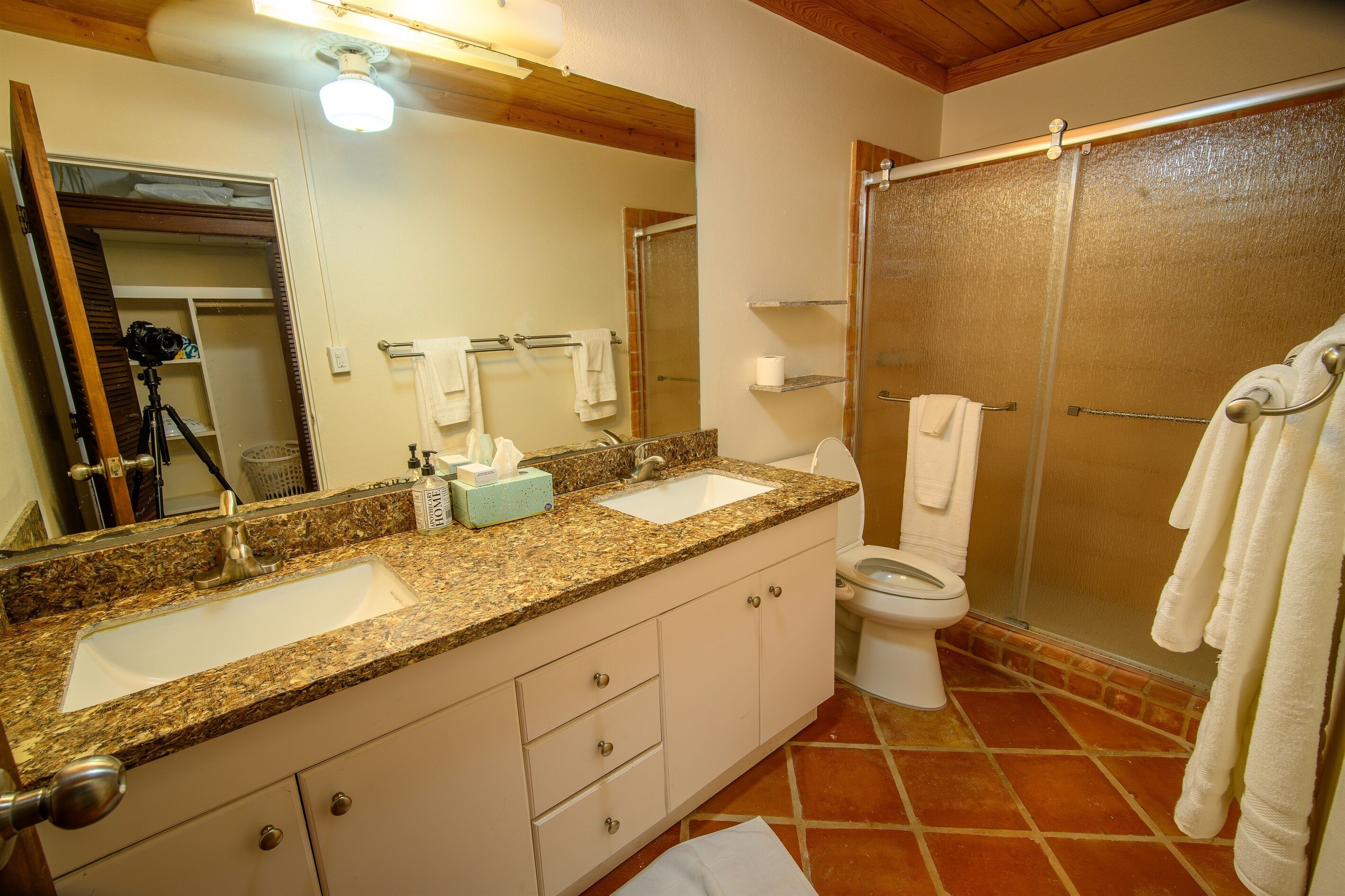 A bathroom with two sinks, a toilet, and a shower.