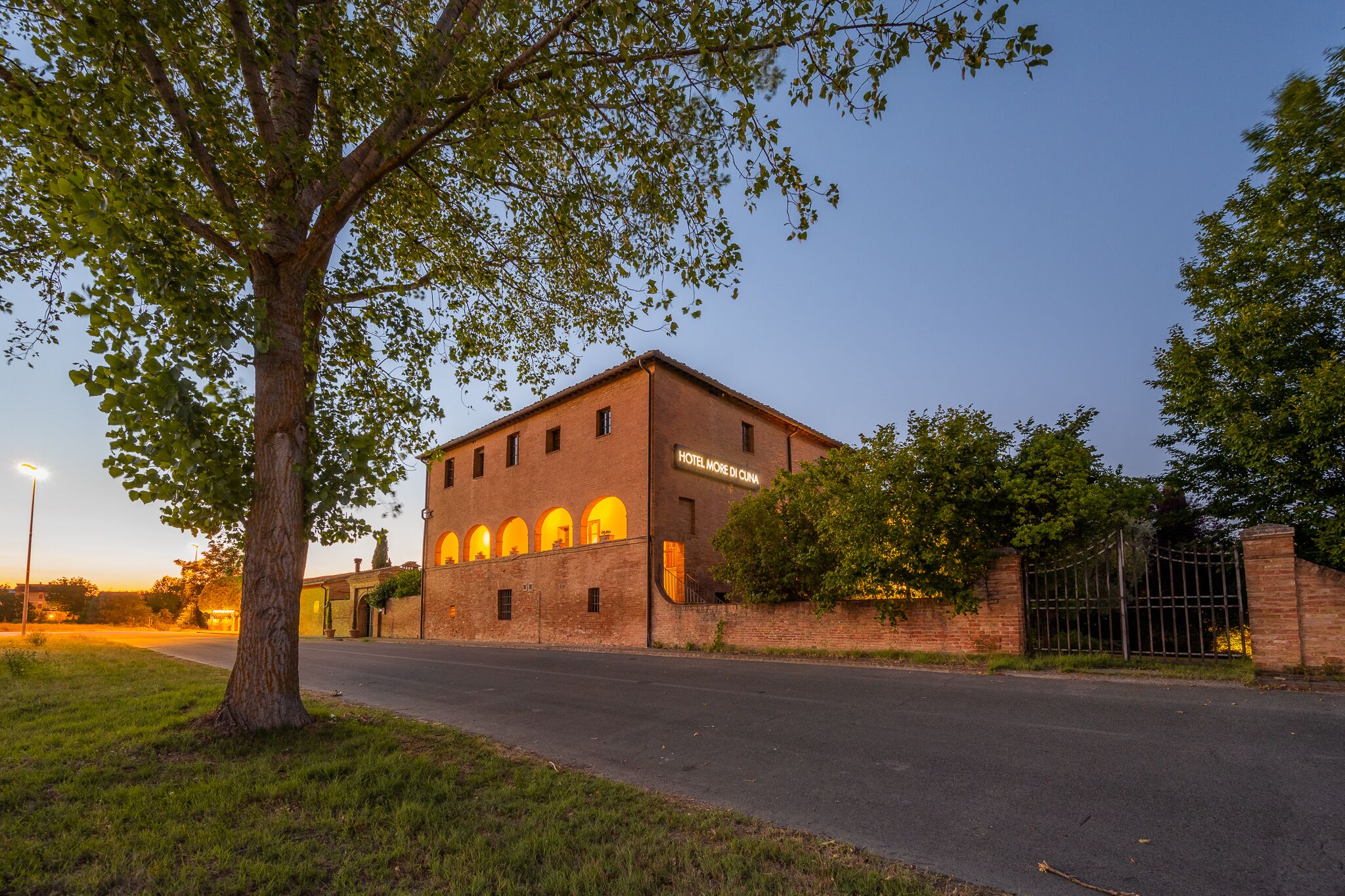 A brick building with arched windows and a sign reading "HOTEL MORE DI CIANA."
