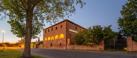 A brick building with arched windows and a sign reading "HOTEL MORE DI CIANA."
