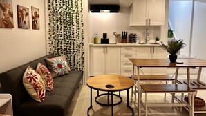 Uma sala de estar moderna com um sofá, uma mesa de centro e um espaço de jantar com mesa e cadeiras.