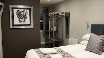 Habitación doble Deluxe, 1 cama matrimonial | Tabla de planchar con plancha y ropa de cama