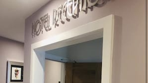 Zona de recepción de un hotel con mostrador y escritorio de mármol.