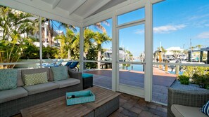 A covered outdoor seating area with a view of a marina and boats. - Private Dock, Heated Pool & Beach Days (Holmes Beach)