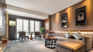 A modern hotel room with a sofa, armchairs, a coffee table, and a large window with curtains. - Kai Li Heaven-sent Resort Hotel (Kaili)