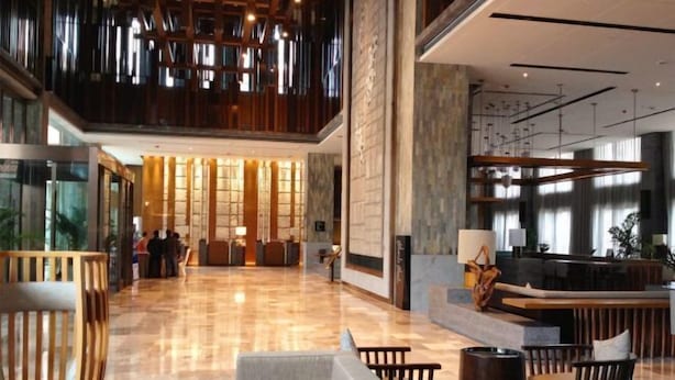 A spacious lobby with a reception desk, seating area, and a high ceiling with hanging lights. - Kai Li Heaven-sent Resort Hotel (Kaili)