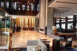 A spacious lobby with a reception desk, seating area, and a high ceiling with hanging lights. - Kai Li Heaven-sent Resort Hotel (Kaili)