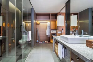 A modern bathroom with a glass shower enclosure, a large sink, and a walk-in shower.