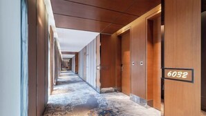 A hotel corridor with wooden doors, numbered 6032, and a patterned carpet. - Kai Li Heaven-sent Resort Hotel (Kaili)
