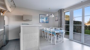 A modern kitchen with a dining area, large windows, and a view of the outdoors. - House for 6 - Cap sur l'Océan - Pool (Arzon)