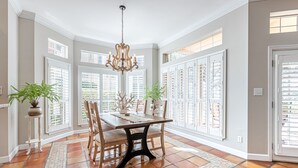 A dining area with a table, chairs, and a chandelier. - Steps From the Beach ~ Golf Cart ~ Community Pool (Miramar Beach)