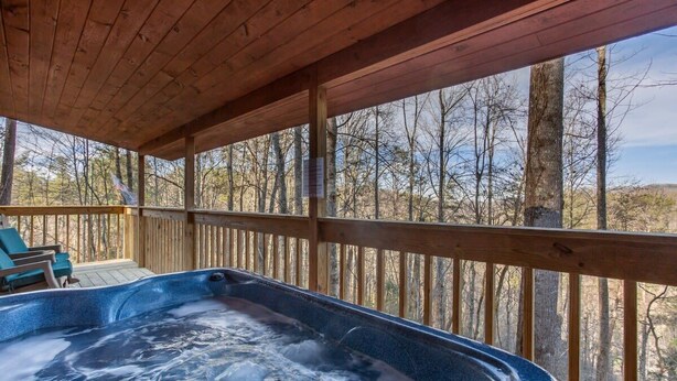 A hot tub on a wooden deck with a view of trees. - Gorgeous Mountain Views/Hot Tub (Sevierville)