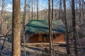 A log cabin with a green roof, surrounded by trees. - Gorgeous Mountain Views/Hot Tub (Sevierville)
