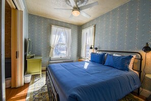 A bedroom with a bed, a ceiling fan, a radiator, and a window with curtains. - Alpine House — Historic Leadville Victorian, 4BR Walk to Harrison Ave, Sleeps 10 (Leadville)