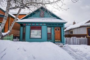 A small, single-story house with a steeply pitched roof and a front porch.