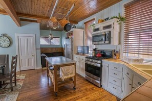 A kitchen with a wooden ceiling, a stove, a microwave, and a sink. - The Ice Palace — 5BR Victorian Sleeps 12, Walk to Downtown Leadville (Leadville)