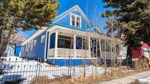 A two-story house with a blue exterior, a front porch, and a fenced yard. - Josephine — Restored 4BR Victorian, Hot Tub, Walk to Main St Leadville, Sleeps 8 (Leadville)
