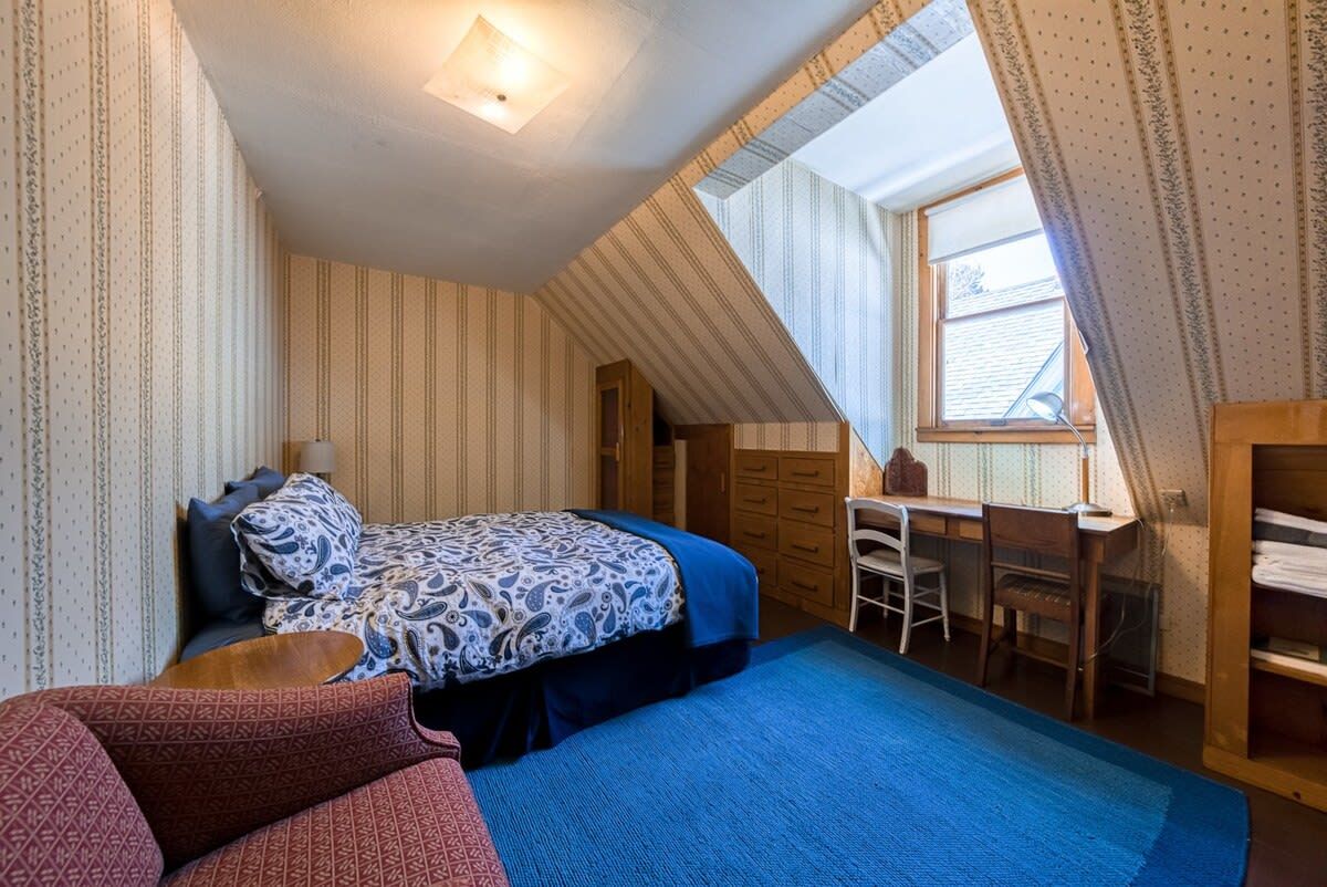 Une chambre à coucher avec un lit, un bureau et une chaise.