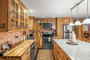 A kitchen with wooden cabinets, a microwave, stove, refrigerator, and a marble countertop. - 2BR Cabin–⁠Deck Lake View & Access–⁠BBQ, Pets OK! (Leadville)