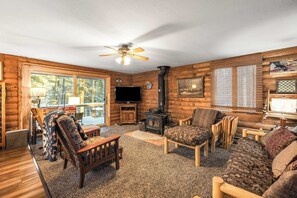 A cozy log cabin interior with a fireplace, wooden furniture, and a television. - 2BR Cabin–⁠Deck Lake View & Access–⁠BBQ, Pets OK! (Leadville)